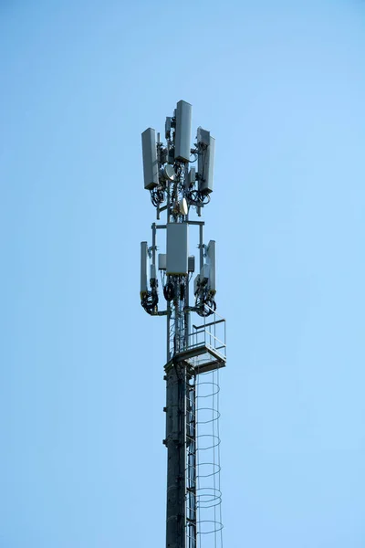 Cellular communication on the pole. High-rise telephone pole in a field in the countryside.