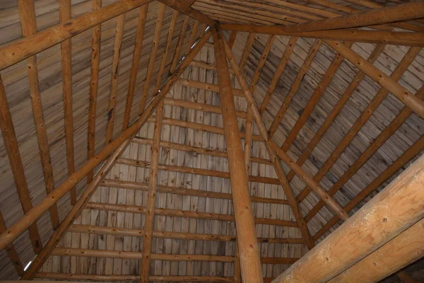 Beams made of logs under the dome of the roof. House made of natural logs. Wooden building.