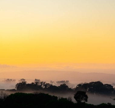 Güneşin doğuşunu izleyen sis.