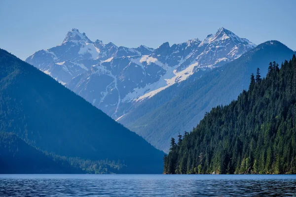 Washington, Kuzey Cascades Ulusal Parkı 'ndaki Rdoubt Dağı' nın sarp ve buzlu zirveleri, Kanada 'nın başkenti BC' de mavi Chilliwack Gölü 'nde (Sxotsaquel) izleyicilerin dikkatini çeker.