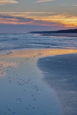 Kış günbatımının son renkli izleri, Güney Carolina 'daki Hilton Head Adası' ndaki sahil şeridini kaplayan ince deniz suyu filmine yansıyor..