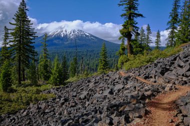 Pacific Coast Trail winds through lava fields in southern Oregon and rewards with splendid views of Mount MaLoughlin with a light topping of snow and cloud clipart