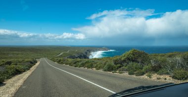 Kanguru Adası 'nın dramatik kıyı şeridinin yanından Flinders Chase Ulusal Parkı' ndaki Kayalıklara uzanan sakin, dalgalı bir anayol.