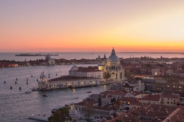 Venedik, İtalya - 07 Ekim 2019: Batan güneşten gelen pembe ışık, Büyük Kanal 'ın karşısındaki Santa Maria della Salute Bazilikası' na ve Campanile 'in tepesinden St. Mark Meydanı' nın bir kısmına büyülü bir hava veriyor.)