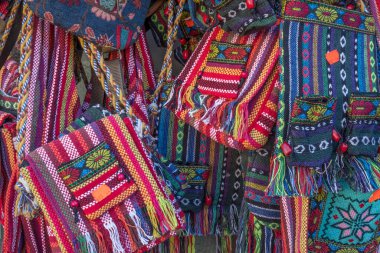 Woven bags available in a rainbow of colors are hung outside a store in Sighisoara, Romania and are for sale to tourists wanting a colorful souvenir