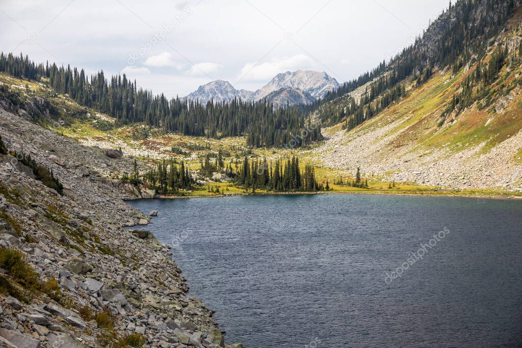 Surrounded with steep cliffs and rockslides, deep blue Kokanee Lake is rippled by gentle winds.  It is accessed by the Kokanee Lake hiking trail, Kokanee Glacier Provincial Park, BC, Canaa