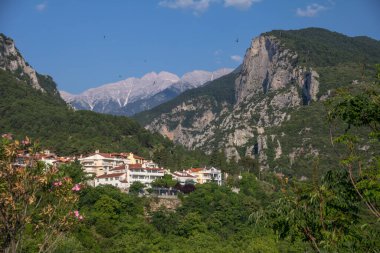 Yunanistan 'ın Litochoro kasabasından Olympus Dağı' nın zirvesine bakıyorum. Birkaç siyah kuş tepemizde daireler çiziyor. Dağların oluşturduğu sabahın erken saatlerinin tadını çıkarıyorlar..