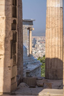 Parthenon 'un mermer sütunlarından Propylaea Giriş Kapısı' na ve modern Atina şehrine bakın