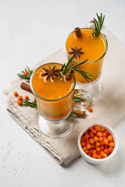 Sea buckthorn drink with rosemary in glass on white background, copy space, top view, verical