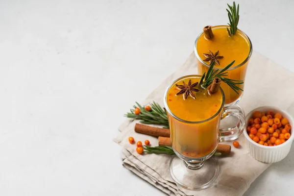 Sea buckthorn drink with rosemary in glass on white background, copy space, top view