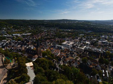 Kilisesi ve çevresindeki yeşillikleri olan bir Avrupa kasabasının havadan görünüşü.