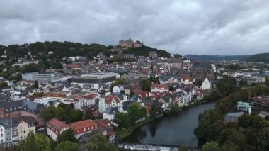 Nehir, tepeler ve şatosu olan bir Avrupa kasabasının havadan görünüşü.