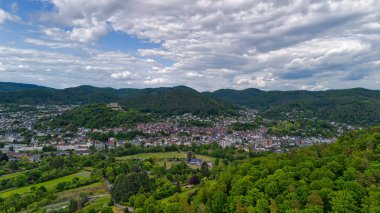 Şehir ve tepeleri olan yemyeşil bir vadinin havadan görünüşü.