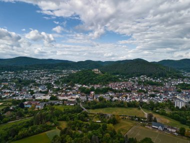 Şehir ve tepeleri olan yemyeşil bir vadinin havadan görünüşü.