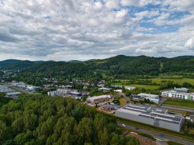 Şehir ve tepeleri olan yemyeşil bir vadinin havadan görünüşü.