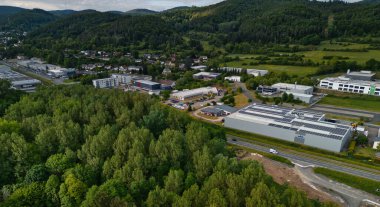 Bereketli yeşil ormanlar ve tepelerle çevrili bir sanayi bölgesinin havadan görüntüsü..