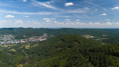 Şehir ve tepeleri olan yemyeşil bir vadinin havadan görünüşü.