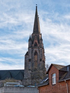 Mavi gökyüzünde sivri kulesi olan gotik kilise kulesi..