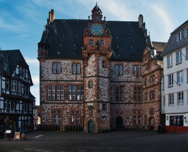 Bir kaldırım taşı meydanında saat kulesi olan tarihi Avrupa binası.