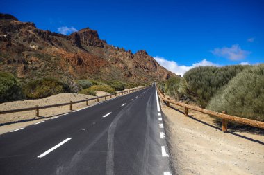 Issız bölgede ıssız bir yol, mavi gökyüzü Vulcano Teide