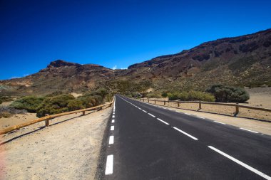 Issız bölgede ıssız bir yol, mavi gökyüzü Vulcano Teide