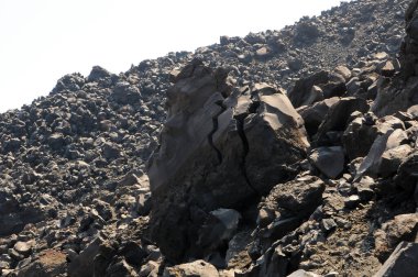 Keskin kenarlı siyah volkan kayaları ve iki belirgin çatlak, desenli görünüş