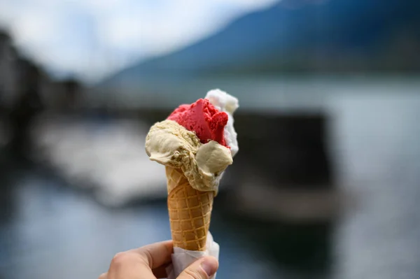 Italian ice cream cone in hand with blury background