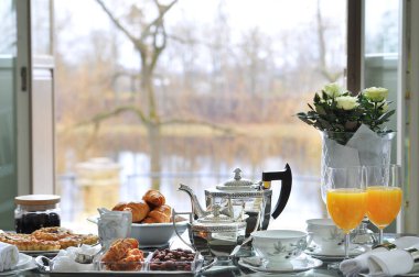 Masada kruvasanlarla, bademlerle servis edilen zengin kahvaltı.
