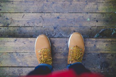 Turuncu, kahverengi çizmeli ıslak tahta. Yürüyüş kavramı.