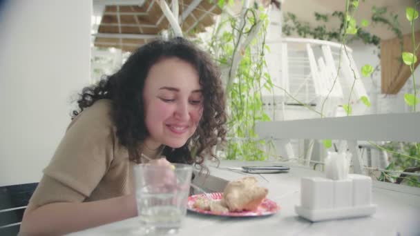 Παιχνιδιάρικη χαρούμενη γυναίκα απολαμβάνοντας την τούρτα και χαμογελώντας — Αρχείο Βίντεο