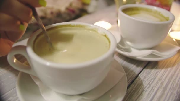 Una joven ama de casa cariñosa está revolviendo azúcar en una taza con café aromático caliente. Primer plano de una mano de las mujeres atractivas jóvenes ella está removiendo el azúcar en una taza con aromático café natural. — Vídeo de stock