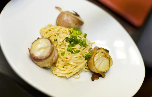 Bacon wrapped scallops and fettuccini — Stock Photo, Image