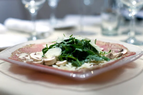 Prosciutto and arugula salad with mushrooms and cheese — Stock Photo, Image