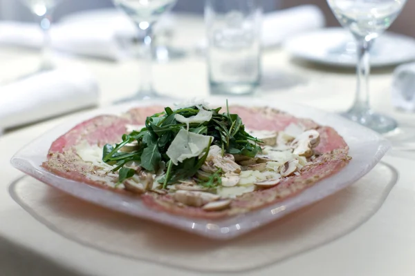 Prosciutto and arugula salad at upscale dinner — Stock Photo, Image