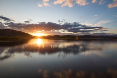 Bulutlu havada Salagou Gölü 'nde uzun süre gün batımı (Occitanie, Fransa)