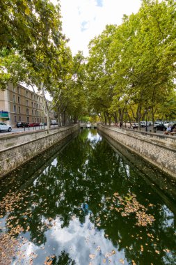 Nimes 'teki ağaçların altında Kanal de la fontaine (Occitanie, Fransa)