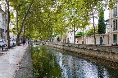 Nimes 'teki ağaçların altında Kanal de la fontaine (Occitanie, Fransa)