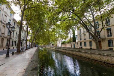 Nimes 'teki ağaçların altında Kanal de la fontaine (Occitanie, Fransa)