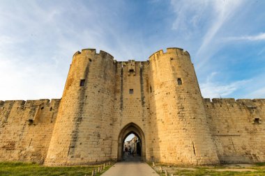Surlarda gün batımı ve ortaçağ Aigues-Mortes kasabasının güçlendirilmiş kapılarından biri (Occitanie, Fransa)