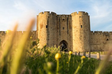 Surlarda gün batımı ve ortaçağ Aigues-Mortes kasabasının güçlendirilmiş kapılarından biri (Occitanie, Fransa)