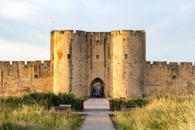 Surlarda gün batımı ve ortaçağ Aigues-Mortes kasabasının güçlendirilmiş kapılarından biri (Occitanie, Fransa)