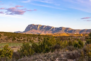 Pic Saint-Loup 'un kuzey yüzü, batan güneş tarafından aydınlatılmıştır (Occitanie, Fransa)