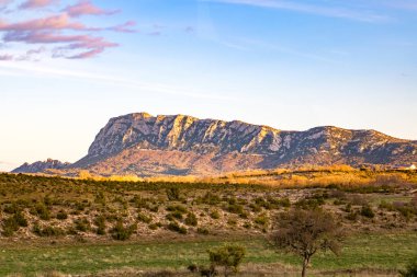 Pic Saint-Loup 'un kuzey yüzü, batan güneş tarafından aydınlatılmıştır (Occitanie, Fransa)