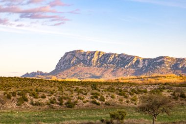 Pic Saint-Loup 'un kuzey yüzü, batan güneş tarafından aydınlatılmıştır (Occitanie, Fransa)