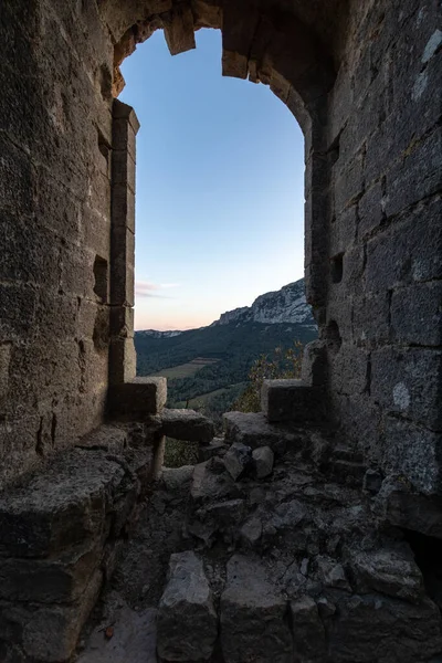 Günbatımında Pic Saint-Loup manzaralı Hortus Dağı Kalesi 'nin bir penceresinin kalıntıları (Occitanie, Fransa)