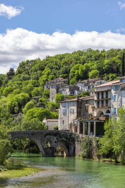 Vidourle (Occitanie, Fransa) kıyısındaki ortaçağ köyü Sauve 'nin eski evleri ve orman manzarası)