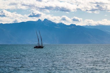 Cenevre Gölü 'nün ortasında küçük bir yelkenli.)
