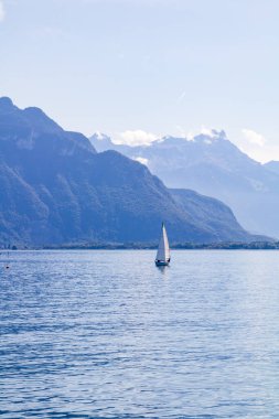 Cenevre Gölü 'nün ortasında küçük bir yelkenli.)