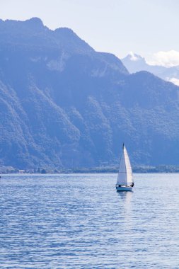 Cenevre Gölü 'nün ortasında küçük bir yelkenli.)