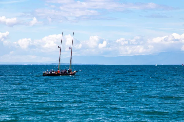Cenevre Gölü 'nün ortasında küçük bir yelkenli.)